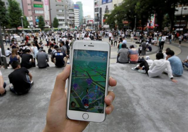 Numerosas personas disfrutan con el "Pokémon GO", el juego para smartphones que cuenta con más de 50 millones de jugadores en el mundo, en un parque de Tokio, Japón, hoy, 25 de julio de 2016. La Bolsa de Tokio retrocedió hoy muy levemente debido a un ligero encarecimiento del yen frente al dólar y al fuerte desplome de Nintendo, a raíz de que la compañía minimizara el impacto del videojuego "Pokémon GO" en sus resultados financieros. EFE/KIMIMASA MAYAMA