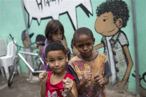 En esta imagen, tomada el 22 de julio de 2016, un grupo de niños posa para una fotografía con una pose de boxeo en una escuela en la favela Ciudad de Dios, en Río de Janeiro, Brasil. Leo Sagat, que gestiona la escuela de boxeo, imparte clases gratuitas porque sabe que el deporte puede inspirar a algunos a alejarse de la favela. Su ejemplo más claro está en la recién coronada campeona olímpica de judo, Rafaela Silva. (AP Foto/Silvia Izquierdo)