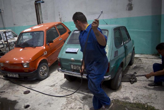 Ramsés Fernández trabaja en un Fiat Polski 126p en La Habana, Cuba, el 10 de agosto de 2016. Fernández es propietario de un Polski, que es su mayor tesoro. Es casi del tamaño de un refrigerados, con un espacio similar al que hay entre los asientos de un vuelo en clase económica y con una potencia un poco mayor al de una podadora. (AP Foto/Ramón Espinosa)