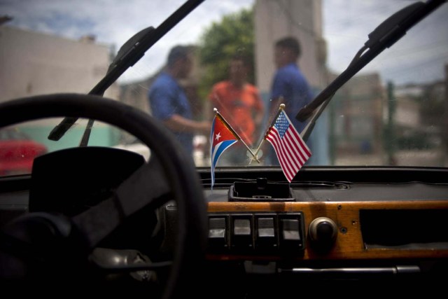 Banderas cubanas y estadounidenses colocadas en el parabrisas de un Fiat Polski 126p, en un garaje de La Habana, el 10 de agosto de 2016. Los mecánicos autodidactas que han logrado mantener en operación por décadas los autos clásicos estadounidenses, ahora usan su talento en estos pequeños artefacto de la Guerra Fría, a los cuales equipan con suspensiones más fuertes, motores más poderosos e incluso sistemas de sonido de alta potencia y nueva tapicería. (AP Foto/Ramón Espinosa)