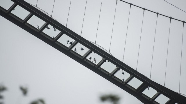 The world's highest and longest glass-bottomed bridge is seen above a valley in Zhangjiajie in China's Hunan Province on August 20, 2016. / AFP PHOTO / FRED DUFOUR