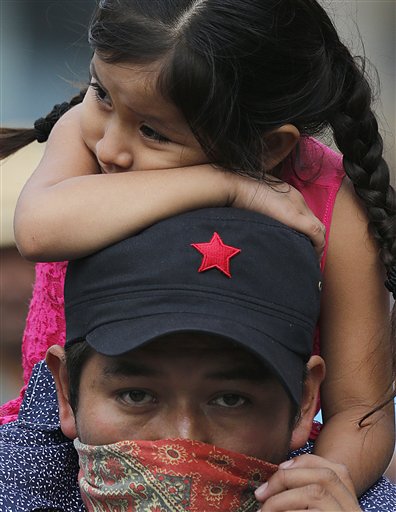 En esta imagen del lunes 22 de agosto de 2016, un profesor lleva a su hija sobre los hombros durante la marcha de un sindicato disidente de profesores en Ciudad de México. Las huelgas de maestros han impedido el inicio de las clases en tres estados de México, en un intento de detener un proyecto de reforma educativa del gobierno. (AP Foto/Marco Ugarte)