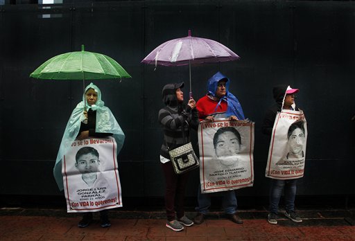 En esta imagen del 24 de agosto de 2016, familiares y profesores disidentes sostienen imágenes de algunos de los 43 estudiantes desaparecidos de la norma rural Isidro Burgos, durante una protesta ante la oficina del procurador general de México, en Ciudad de México. Un mes antes de que se cumplan dos años de la desaparición de los estudiantes en Iguala, en el estado sureño de Guerrero, los familiares siguen pidiendo justicia para los desaparecidos. (AP Foto/Marcos Ugarte)