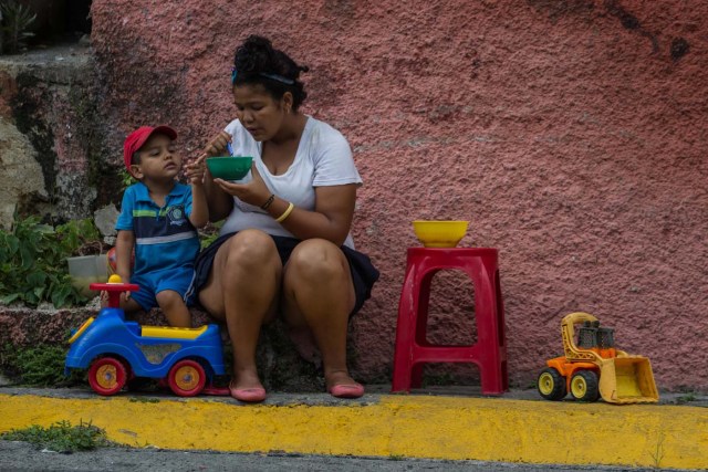 CAR07. CARACAS (VENEZUELA), 10/09/2016.- Habitantes comen de un sancocho comunal hoy, sábado 10 de septiembre del 2016, en la ciudad de Caracas (Venezuela). En el barrio la Unión, ubicado en la favela más grande de América Latina asentada en el este de Caracas, se preparó hoy un gran "sancocho" como se le conoce en Venezuela a la sopa cocinada con varios tipos de verduras y carnes, para alimentar a los vecinos, muchos de ellos con varios días de hambre. EFE/MIGUEL GUTIÉRREZ