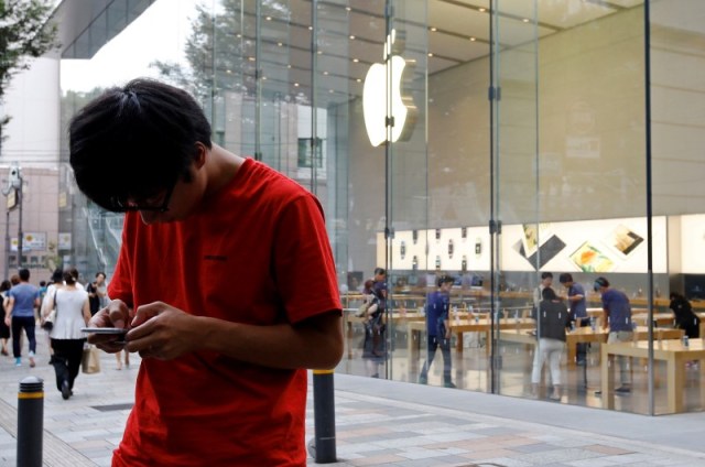 Una persona usa su iPhone 6 Plus mientras espera el lanzamiento del nuevo iPhone 7 y 7 Plus frente a una tienda Apple, en el distrito financiero Omotesando, Tokio, Japón. 15 de septiembre de 2016. Las cantidades iniciales del iPhone 7 Plus se han agotado en todo el mundo, dijo Apple la noche del miércoles, en momentos en que la compañía se prepara para llevar su nuevo dispositivo a las tiendas. REUTERS/Toru Hanai