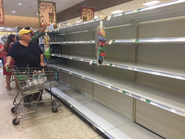 Shoppers pass by empty shelves as they buy supplies ahead of the arrival of hurricane Matthew in Daytona Beach, on October 5, 2016. Weakened but still dangerous, Hurricane Matthew churned toward the Bahamas en route to an already jittery Florida after killing at least nine people in the Caribbean in a maelstrom of wind, mud and water. / AFP PHOTO / Leila MACOR