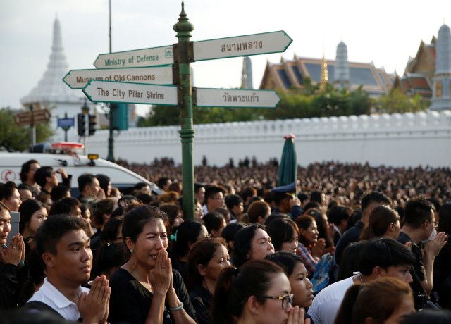 Mourners react as a motorcade carrying the body of Thailand's King Bhumibol Adulyadej arrives at the Grand Palace in Bangkok, Thailand October 14, 2016. REUTERS/Edgar Su