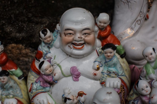 This picture taken on August 9, 2016 shows ants crawling over a discarded statue of a deity, on a rocky slope running down to the sea in Hong Kong. Religion and local customs permeate Hong Kong, where Buddhist and Taoist temples are common and incense offerings are regularly burned outside local businesses. Private homes often have a shrine to a local deity, with Christian churches and mosques also in the mix. But with space at a premium in a city were rents are sky high, informal collections of discarded gods often decorate roadsides and public spaces. / AFP PHOTO / Anthony WALLACE / To go with "HONG KONG-CULTURE-LIFESTYLE-RELIGION", FEATURE by Dennis Chong