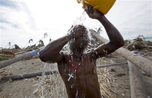 En esta fotografía del 25 de octubre de 2016, Jimmy Jeudy se baña con agua de un pozo contaminado con agua de mar y basura durante el paso del huracán Matthew, en Aux Coteaux, un distrito de Les Cayes, Haití. El agua de los pozos y los ríos en toda la región también tienen la bacteria del cólera, que los epidemiólogos sospechan ha enfermado a miles de personas desde el paso de la tormenta. (AP Foto/Dieu Nalio Chery)