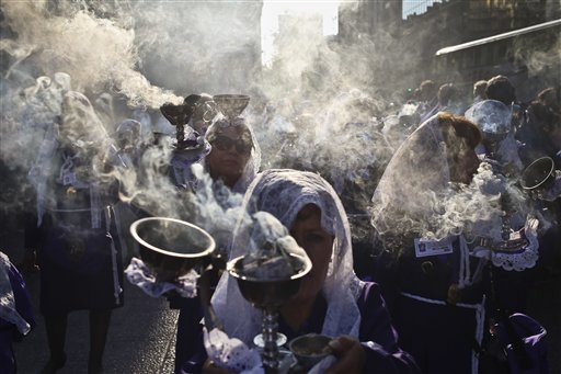 En esta fotografía del 29 de octubre de 2016, mujeres con velos llevan incensarios durante una procesión en honor del Señor de los Milagros en la Plaza de Armas en Santiago, Chile. Los peruanos en Chile se reunieron para participar en la procesión para celebrar al Señor de los Milagros, el santo patrono de la mayoría de los católicos peruanos. (AP Foto/Esteban Félix)