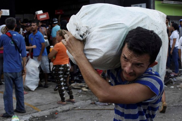 People carry goods taken from a food wholesaler after it was broken into, in La Fria, Venezuela December 17, 2016. REUTERS/Carlos Eduardo Ramirez