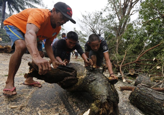 FRM101. Milaor (Philippines), 25/12/2016.- Filipino villagers clear debris from a road in the typhoon-hit town of Milaor, Camarines Sur, Philippines, 26 December 2016. According to Office of Civil Defense (OCD) reports on 26 December, hundreds of thousands of villagers spent their Christmas day in evacuation centers in Bicol region, many flights were cancelled at Manila's internatioanal airport, and scores of sea vessels have reportedly sunk as Typhoon Nock-ten brought howling winds and strong rains in central Philippines. (Filipinas) EFE/EPA/EUGENIO LORETO