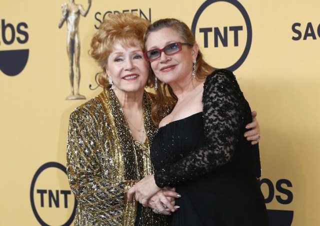 Foto de archivo de la actriz Debbie Reynolds posando con su hija Carrie Fisher tras recibir un premio a la trayectoria del Sindicato de Actores de Cine. Ene 25, 2015. Debbie Reynolds, quien en las décadas de 1950 y 1960 brilló en películas como "Cantando bajo la lluvia", fue hospitalizada el miércoles, un día después de la muerte de su hija Carrie Fisher, reportaron E! News y TMZ. REUTERS/Mike Blake