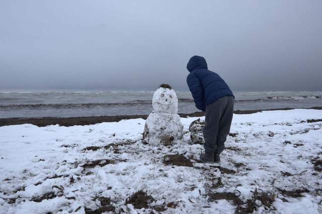 GRA016. DÉNIA (ALICANTE), 18/01/2017. Un niño juega con un muñeco de nieve en la playa de Les Marines, en Denia, completamente nevada desde primeras horas de la mañana.El Centro de Coordinación de Emergencias de la Generalitat ha decretado la emergencia por nevadas situación cero en las comarcas de La Vall d'Albaida y La Safor, en la provincia de Valencia, y en La Marina Alta, L'Alcoià y El Comtat, en la provincia de Alicante. EFE/Natxo Francés