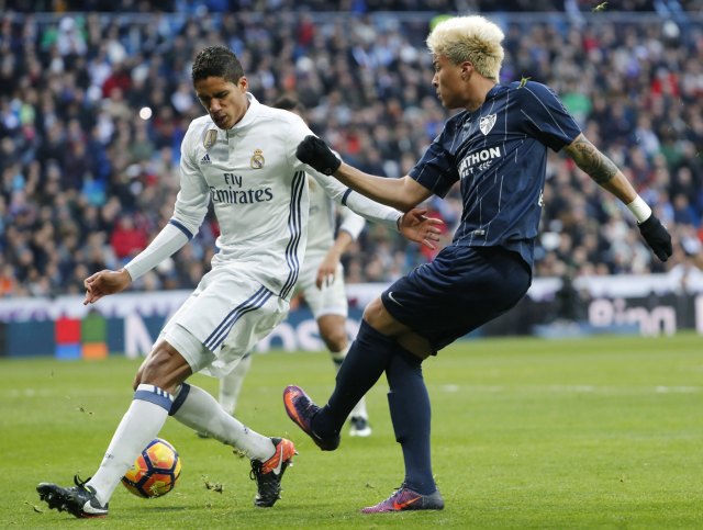 El defensa del Real Madrid Rafael Varenne (i) y el jugador venezolano de Málaga Adalberto Peñaranda,d, durante el partido de la décima novena jornada de la Liga de Primera División que se juega hoy en el Santiago Bernabéu, en Madrid. EFE/Ángel Díaz