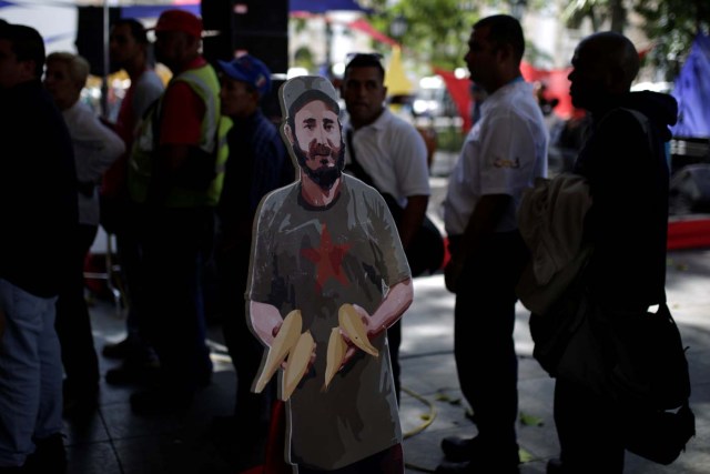 A cardboard cut-out of Cuba's late President Fidel Castro is seen as people wait to apply for a card that will register them for government social programmes