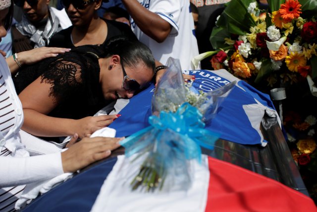 Angela Martinez, mother of Yordano Ventura's daughter, cries on the coffin during the funeral at the Municipal Baseball Stadium of Las Terrenas, Dominican Republic