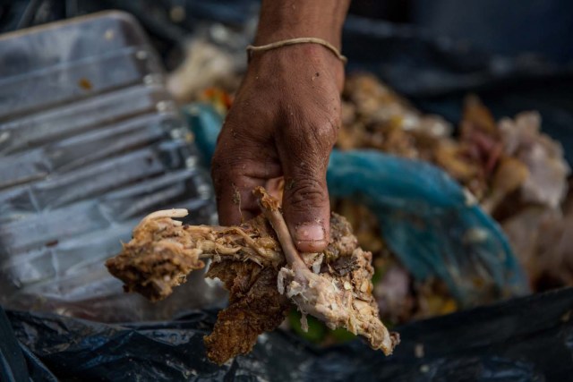 ACOMPAÑA CRÓNICA: VENEZUELA CRISIS. CAR02. CARACAS (VENEZUELA), 31/12/2016.- Varias personas buscan comida entre bolsas de basura este jueves, 31 de diciembre de 2016, en Caracas (Venezuela). La profunda crisis que aqueja a Venezuela trajo como consecuencia escasez y hambre, lo que a su vez ha llevado a familias enteras a buscar restos de alimentos en los basureros y, muchas veces, a pelear con otras personas sin recursos, por un desecho comestible o algún material reciclable que se pueda vender. EFE/Miguel Gutiérrez