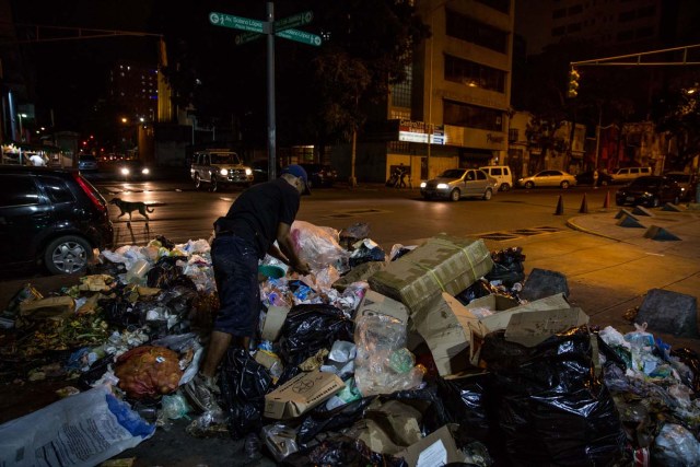 ACOMPAÑA CRÓNICA: VENEZUELA CRISIS. CAR12. CARACAS (VENEZUELA), 31/12/2016.- Varias personas buscan comida entre bolsas de basura este jueves, 31 de diciembre de 2016, en Caracas (Venezuela). La profunda crisis que aqueja a Venezuela trajo como consecuencia escasez y hambre, lo que a su vez ha llevado a familias enteras a buscar restos de alimentos en los basureros y, muchas veces, a pelear con otras personas sin recursos, por un desecho comestible o algún material reciclable que se pueda vender. EFE/Miguel Gutiérrez