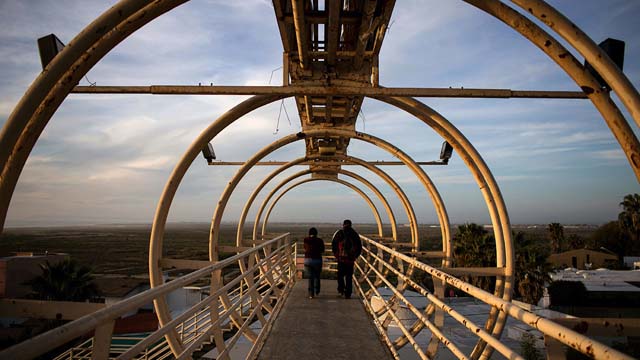 Personas cruzan el puente de la frontera mexicano-estadounidense en San Diego, California.