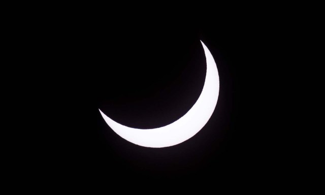 Picture taken on February 26, 2017 showing the moon moving to cover the sun for an annular solar eclipse, as seen from the Estancia El Muster, near Sarmiento, Chubut province, 1600 km south of Buenos Aires, Argentina, on February 26, 2017. Stargazers applauded as they were plunged into darkness Sunday when the moon passed in front of the sun in a spectacular "ring of fire" eclipse. / AFP PHOTO / ALEJANDRO PAGNI