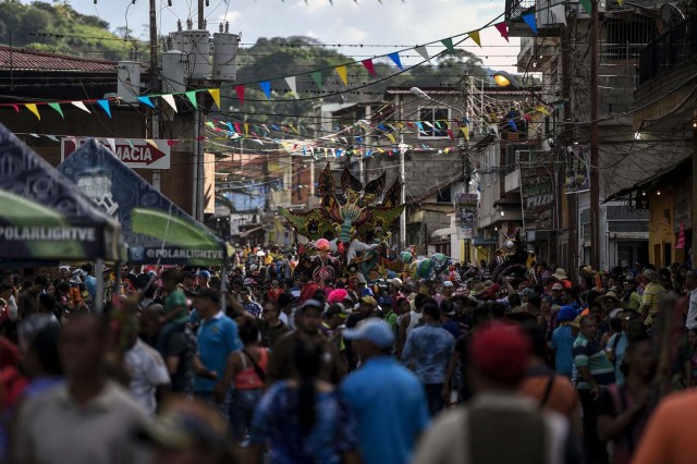 Revellers dance in the carnival parade in the mining village of El Callao, Bolivar state, southeastern Venezuela on February 27, 2017.  El Callao's carnival was recently named Unesco's Intangible Cultural Heritage of Humanity. / AFP PHOTO / JUAN BARRETO / TO GO WITH AFP STORY BY ISABEL SANCHEZ