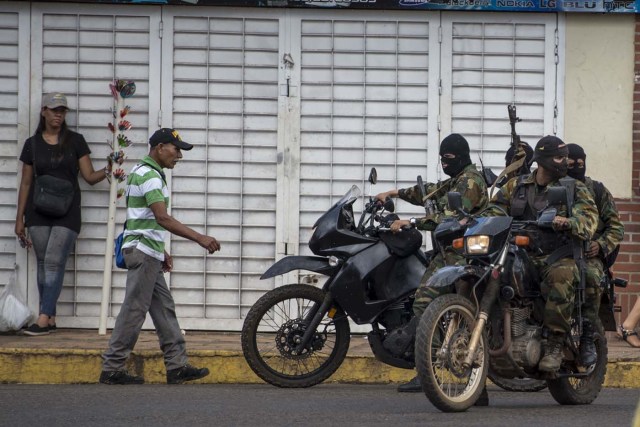 Venezuelan soldiers stand guard during the carnival in El Callao, Bolivar state, southeastern Venezuela on February 27, 2017. El Callao's carnival was recently named Unesco's Intangible Cultural Heritage of Humanity. / AFP PHOTO / JUAN BARRETO / TO GO WITH AFP STORY BY ISABEL SANCHEZ