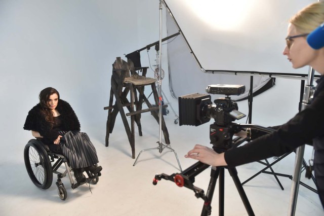 TO GO WITH AFP STORY BY OLGA SHYLENKO A camerawoman makes adjustments prior to a photo and video fashion shoot with Ukrainian model Alexandra Kutas, who is in a wheelchair from a very early age due to a spinal cord injury resulting from a doctor's mistake at birth, in Kiev on January 25, 2017. Kutas, 23, is Ukraine's first model with a disability to headline a runway event of this level, after covering a long and thorny path for her dream to come true. / AFP PHOTO / Sergei SUPINSKY / ?The erroneous mention[s] appearing in the metadata of this photo by Sergei SUPINSKY has been modified in AFP systems in the following manner: [a spinal cord injury resulting from a doctor's mistake at birth] instead of [cerebral palsy]. Please immediately remove the erroneous mention[s] from all your online services and delete it (them) from your servers. If you have been authorized by AFP to distribute it (them) to third parties, please ensure that the same actions are carried out by them. Failure to promptly comply with these instructions will entail liability on your part for any continued or post notification usage. Therefore we thank you very much for all your attention and prompt action. We are sorry for the inconvenience this notification may cause and remain at your disposal for any further information you may require.?