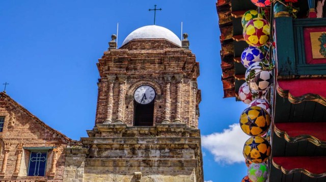 Partial view of the Basilica of Our Lady of Mongui and a ball factory in Mongui, in the Colombian department of Boyaca, taken on February 13, 2017. Mongui, in the central mountains of Colombia, has about 20 football factories that make balls mainly for football and micro-football. About a quarter of the town's 4,900 inhabitants work in these factories. / AFP PHOTO / Luis ACOSTA