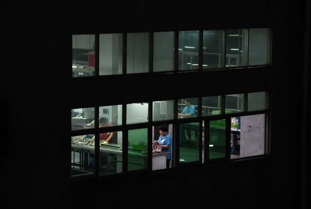 (FILES) This file photo taken on September 14, 2016 shows night-shift workers at the Huajian shoe factory, where about 100,000 pairs of Ivanka Trump-branded shoes have been made over the years amongst other brands, in Dongguan in south China's Guangdong province. In his January inauguration speech, US President Donald Trump made a seemingly straightforward pledge: "We will follow two simple rules: buy American and hire American." His daughter is the exception: even as he spoke, at least eight shipments of Ivanka Trump-branded shoes, bags and clothes -- more than 53.5 tonnes -- were steaming towards American ports from China, according to US Customs bills of lading examined by AFP. / AFP PHOTO / Greg Baker / TO GO WITH China-US-politics-economy-trade-Trump, FOCUS by Ben DOOLEY