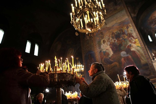Worshippers light candles during the Palm Sunday service in the Alexander Nevsky Cathedral in Sofia, Bulgaria April 9, 2017. REUTERS/Stoyan Nenov