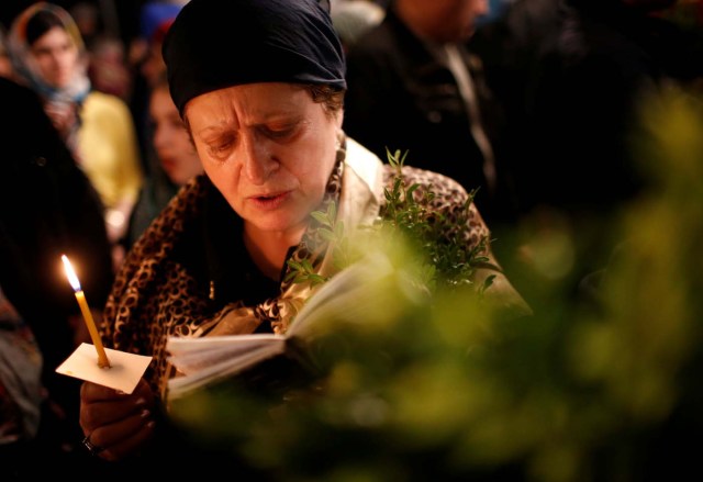 A woman reads a prayer book during the Palm Sunday service in Tbilisi, Georgia April 9, 2017. REUTERS/David Mdzinarishvili