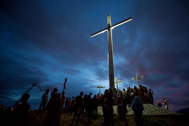 Un grupo de personas participan en la representación del viacrucis hoy, viernes 14 de abril de 2017, por las calles del barrio Petare en Caracas (Venezuela). EFE/MIGUEL GUTIÉRREZ