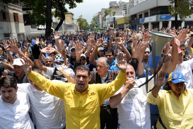 Demonstrators march against Venezuelan President Nicolas Maduro, in Caracas on April 20, 2017. Venezuelan riot police fired tear gas Thursday at groups of protesters seeking to oust President Nicolas Maduro, who have vowed new mass marches after a day of deadly unrest. Police in western Caracas broke up scores of opposition protesters trying to join a larger march, though there was no immediate repeat of Wednesday's violent clashes, which left three people dead. / AFP PHOTO / Federico PARRA