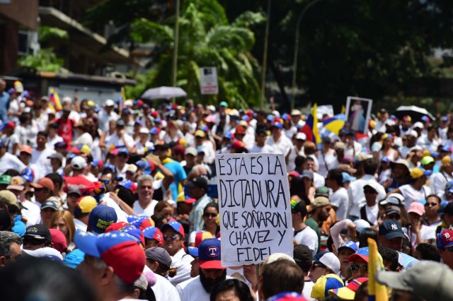 Venezuelan opposition activists rally in Caracas, on April 22, 2017. Venezuelans gathered Saturday for "silent marches" against President Nicolas Maduro, a test of his government's tolerance for peaceful protests after three weeks of violent unrest that has left 20 people dead. / AFP PHOTO / RONALDO SCHEMIDT