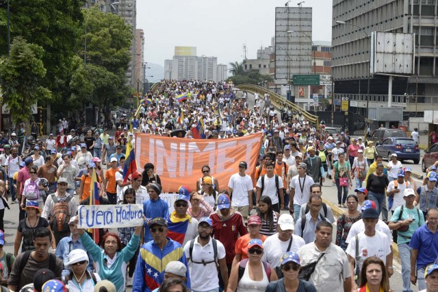 Venezuelan opposition activists march along an avenue in Caracas, on April 24, 2017. Protesters plan Monday to block Venezuela's main roads including the capital's biggest motorway, triggering fears of further violence after three weeks of unrest left 21 people dead. / AFP PHOTO / FEDERICO PARRA