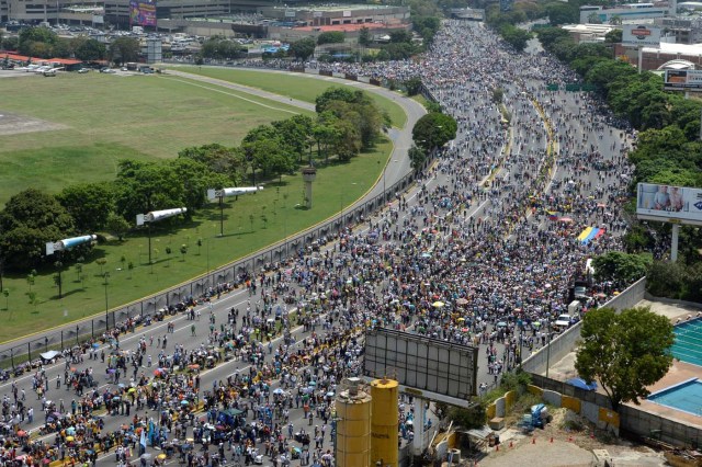 Thousands of Venezuelan opposition activists demonstrate against President Nicolas Maduro in Caracas, on April 24, 2017. Protesters rallied on Monday vowing to block Venezuela's main roads to raise pressure on Maduro after three weeks of deadly unrest that have left 21 people dead. Riot police fired rubber bullets and tear gas to break up one of the first rallies in eastern Caracas early Monday while other groups were gathering elsewhere, the opposition said. / AFP PHOTO / Federico PARRA