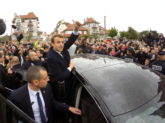 French presidential election candidate Emmanuel Macron, head of the political movement En Marche !, or Onwards ! greets supporters as he leaves a polling station during the the second round of 2017 French presidential election, in Le Touquet, France, May 7, 2017. REUTERS/Philippe Wojazer