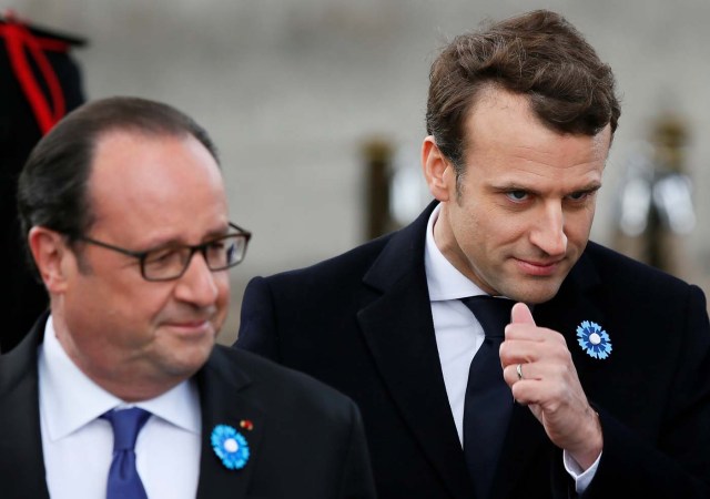 Outgoing French President Francois Hollande (L) and President-elect Emmanuel Macron attend a ceremony to mark the end of World War II at the Tomb of the Unknown Soldier at the Arc de Triomphe in Paris, France, May 8, 2017. REUTERS/Francois Mori/Pool