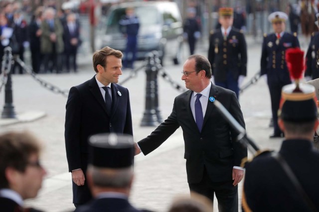 Outgoing French President Francois Hollande (R) and President-elect Emmanuel Macron attend a ceremony to mark the end of World War II at the Tomb of the Unknown Soldier at the Arc de Triomphe in Paris, France, May 8, 2017. REUTERS/Philippe Wojazer