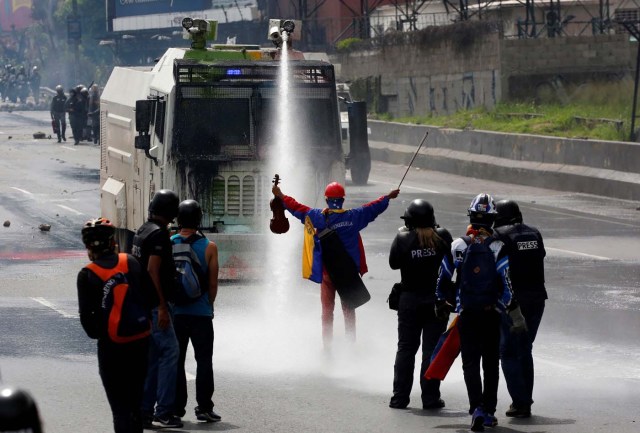 A demonstrator stands in front of a riot security forces vehicle during a rally against President Nicolas Maduro in Caracas, Venezuela, May 24, 2017. REUTERS/Carlos Garcia Rawlins