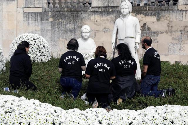 Peregrinos rezan en la estatua de Francisco Marto y Jacinta Marto en el santuario de Fátima, Portugal, hoy 11 de mayo de 2017. El Santuario de Fátima entregará al papa, durante su visita a este centro de peregrinación mañana y el sábado, un grupo escultórico de la Virgen y los tres pastorcillos, con motivo del centenario de las Apariciones que se conmemora este 2017. EFE/Paulo Novais