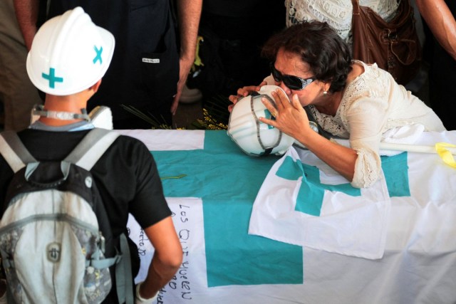 The mother of Paul Moreno, a volunteer, member of a primary care response team who died while on duty during a protest against Venezuelan President Nicolas Maduro’s government, kisses a helmet over his coffin during his funeral in Maracaibo, Venezuela, May 19, 2017. REUTERS/Isaac Urrutia