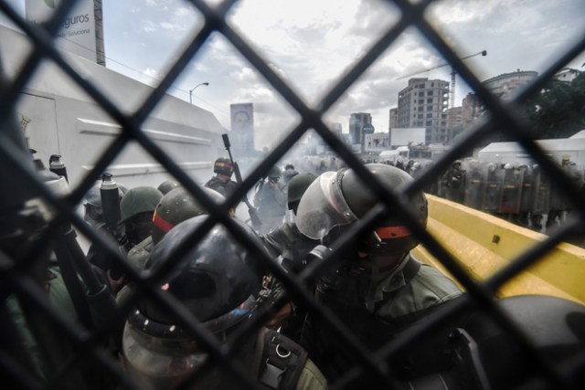 La policía antidisturbios de la Guardia Nacional se mantiene en pie mientras los manifestantes de la oposición se reúnen para protestar en Caracas / AFP PHOTO / JUAN BARRETO