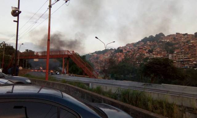 Manifestantes queman cauchos en la vía (Foto:@MikeCarbonell2)