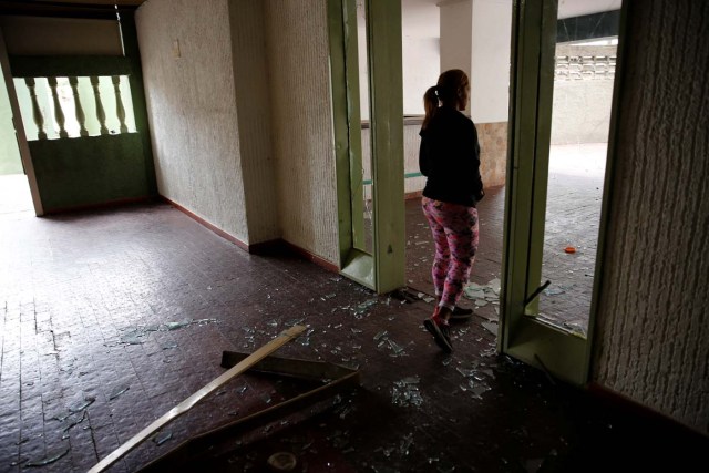 A woman walks through a broken door after opposition supporters and security forces clashed in and outside a residential building on Tuesday according to residents, in Caracas, Venezuela June 14, 2017. REUTERS/Ivan Alvarado