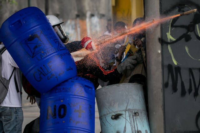 -FOTODELDIA- CAR019 CARACAS (VENEZUELA), 07/06/2017.- Venezolanos opositores se enfrentan a la Policía Nacional Bolivariana (PNB) durante una manifestación hoy, miércoles 7 de junio de 2017, en Caracas (Venezuela). Agentes de la fuerza pública venezolana dispersaron hoy con gases lacrimógenos varias de las manifestaciones convocadas en el país por la oposición hacia las sedes del Poder Electoral para protestar por el eventual cambio de Constitución que impulsa el Gobierno. EFE/MIGUEL GUTIÉRREZ