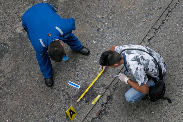 CAR26. CARACAS (VENEZUELA), 08/06/2017 - Trabajadores del Ministerio Público realizan hoy, jueves 8 de junio de 2017, el levantamiento planimétrico en el lugar en el que un joven de 17 años murió durante una protesta opositora, en Caracas (Venezuela). El Ministerio Público venezolano (MP, Fiscalía) cifró hoy en 67 las muertes registradas en hechos violentos relacionados con las protestas a favor y en contra del Gobierno de Nicolás Maduro que sacuden la nación desde hace 69 días. EFE/MIGUEL GUTIÉRREZ