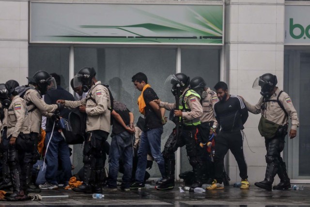 CAR119. CARACAS (VENEZUELA), 29/06/2017.- Agentes de la Policía Nacional Bolivariana detienen a manifestantes durante una marcha hacia la sede del Poder Electoral hoy, jueves 29 de junio de 2017, en Caracas (Venezuela). Diputados de la oposición venezolana denunciaron hoy que las fuerzas del orden reprimieron con perdigones y bombas lacrimógenas una marcha ciudadana a la sede del Poder Electoral para mostrar su rechazo al proceso constituyente activado por el Gobierno para elaborar una nueva Carta Magna. EFE/Miguel Gutiérrez