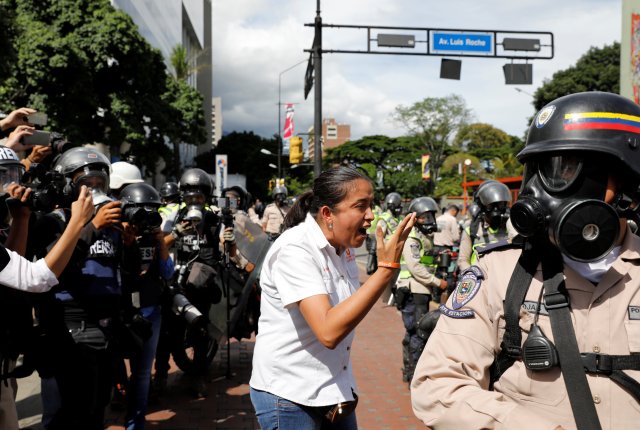 Gaby Arellano (C), lawmaker of the Venezuelan coalition of opposition parties (MUD) gestures toward security forces during a rally against Venezuela's President Nicolas Maduro's government in Caracas, Venezuela June 14, 2017.  REUTERS/Carlos Garcia Rawlins